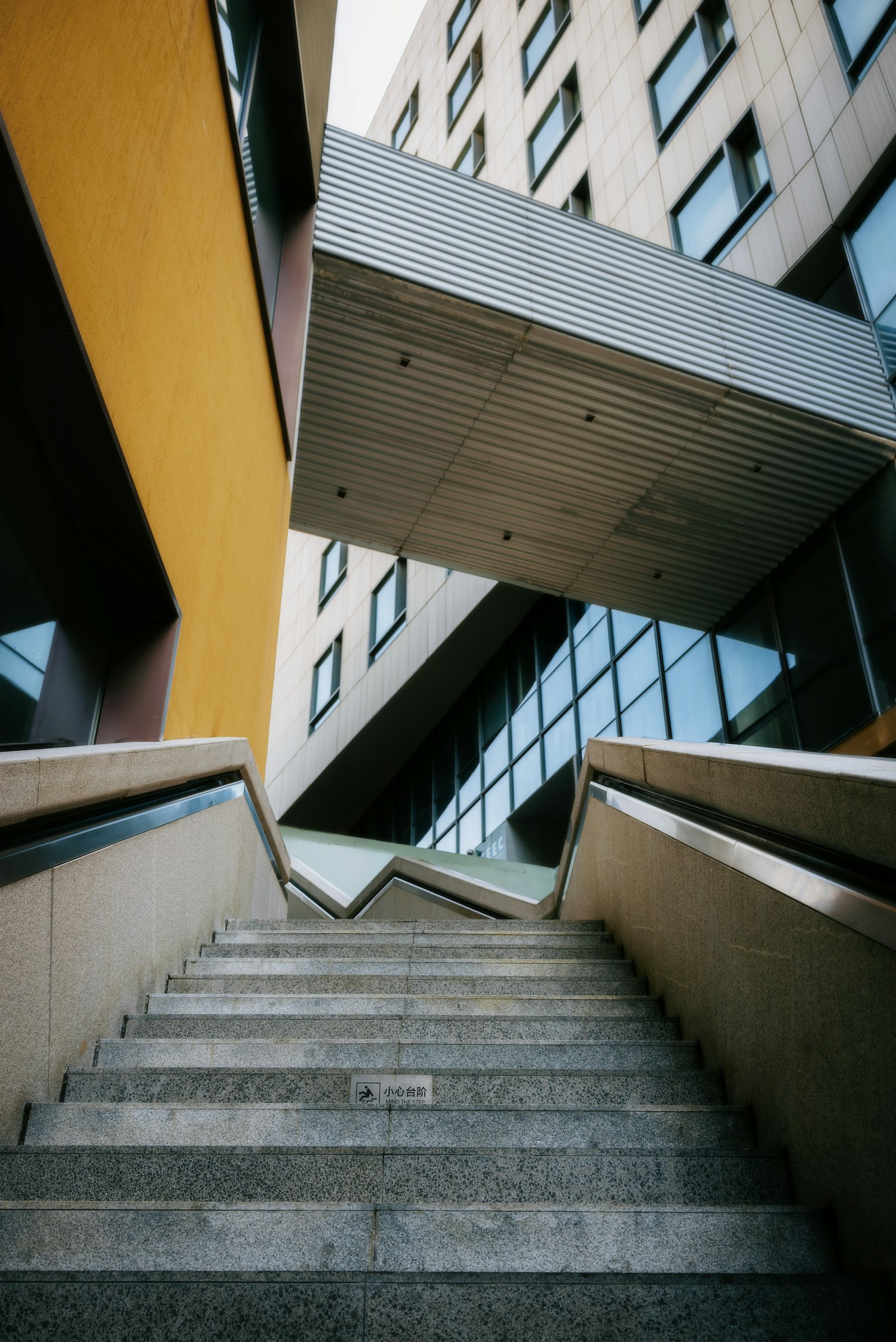 Escadaria geométrica entre planos de arquitetura contemporânea.