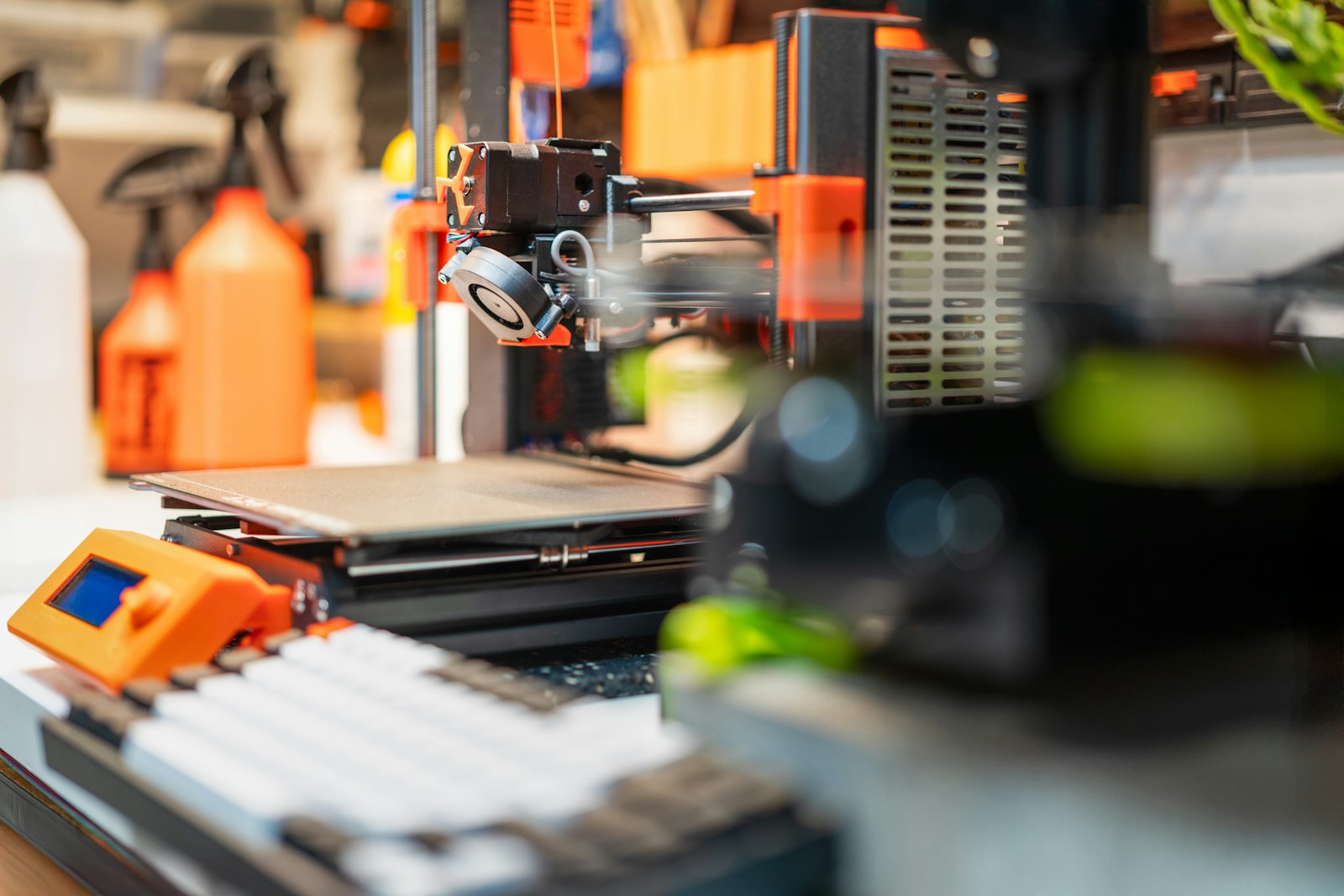Impressora 3D e componentes de prototipagem sobre uma bancada.